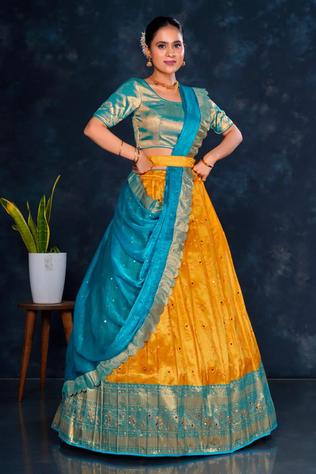 Woman wearing a traditional outfit with a blue and gold Half Saree