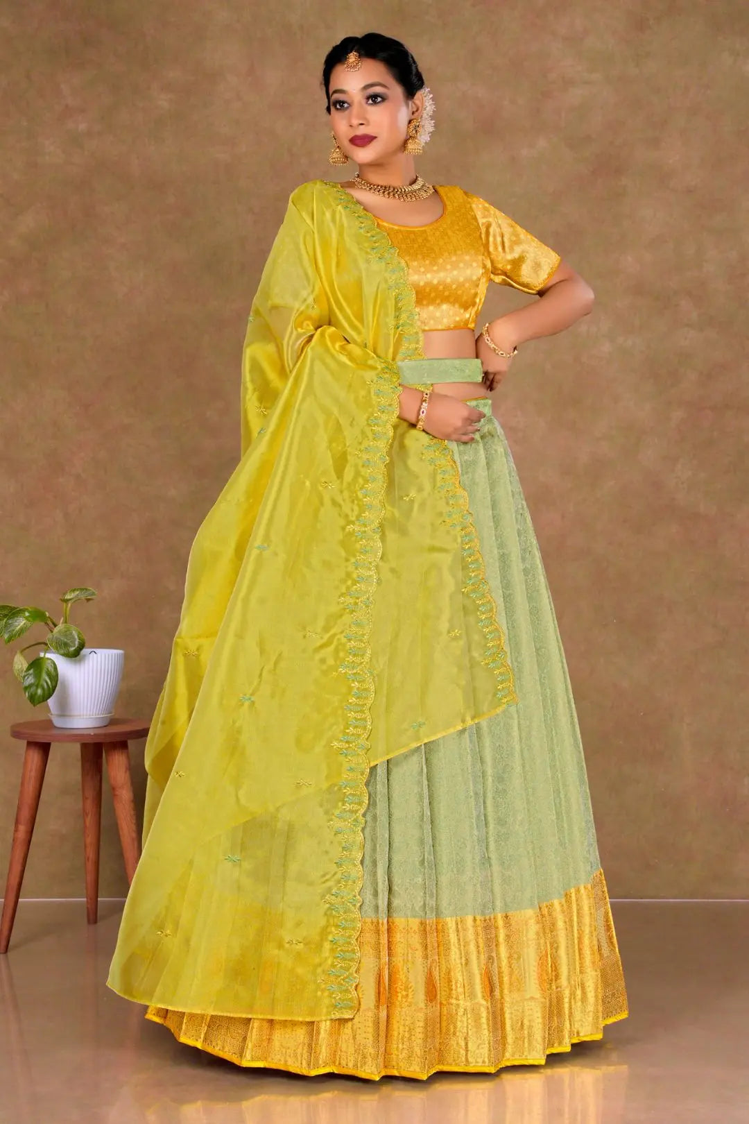 Woman wearing a yellow and green traditional lehenga choli with dupatta