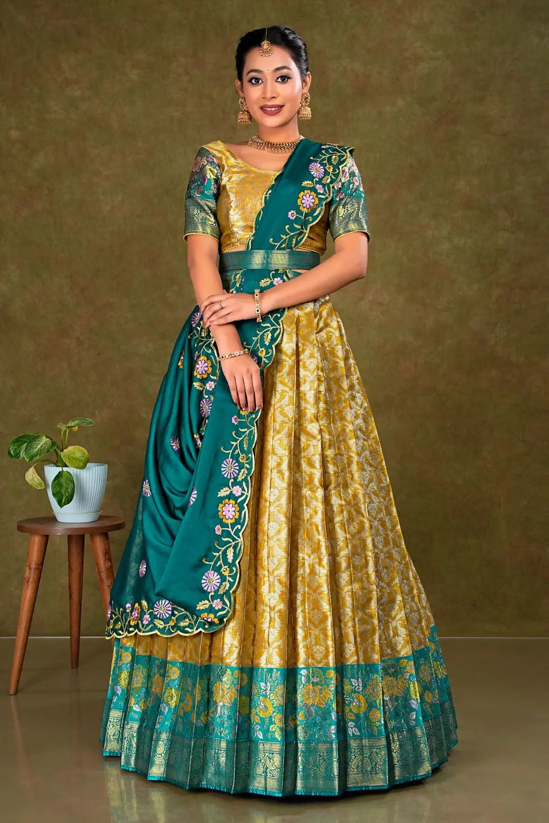 Woman wearing a traditional green and gold lehenga with a matching blouse