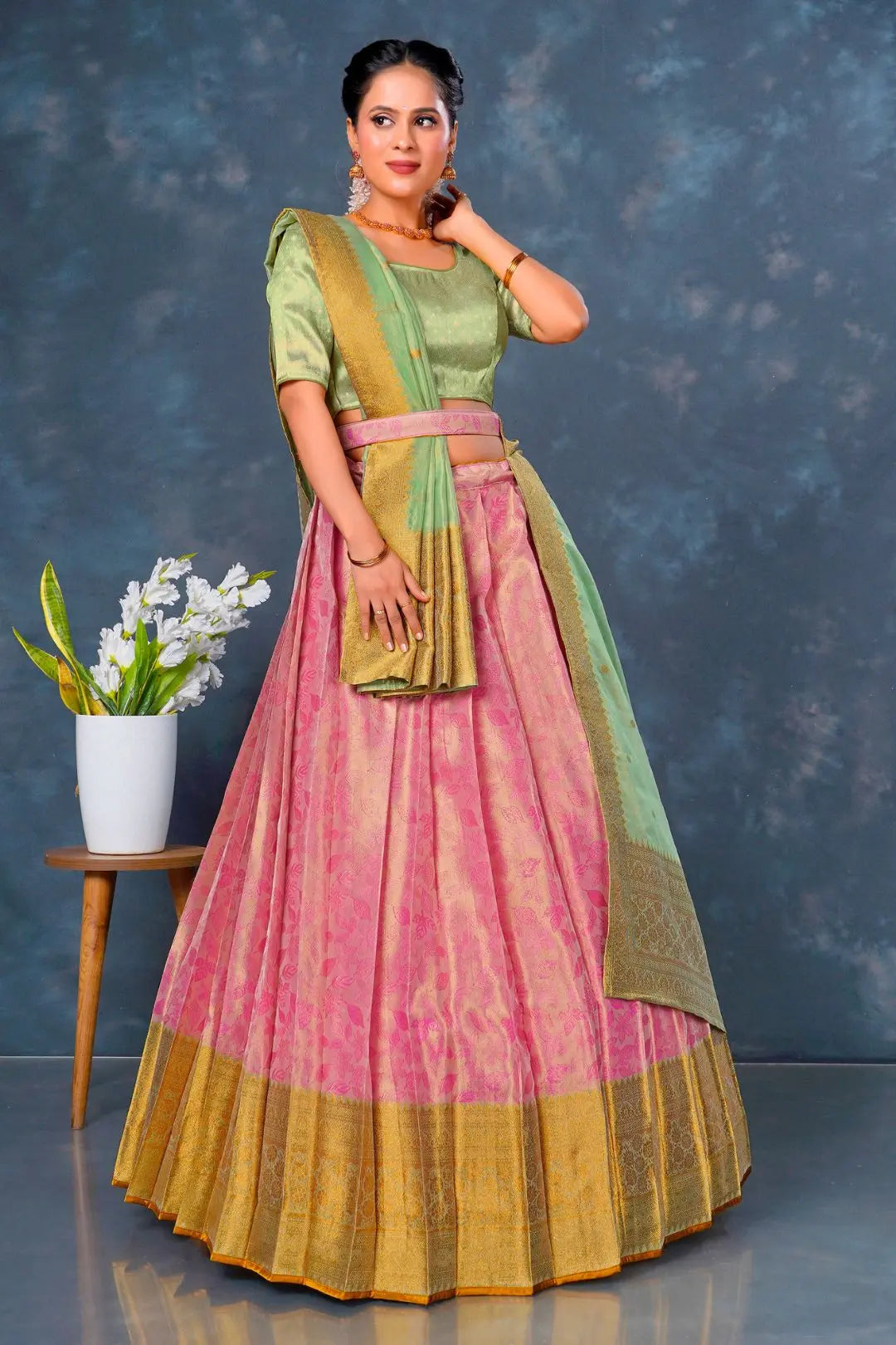 Woman in a traditional outfit with a pink and green lehenga choli