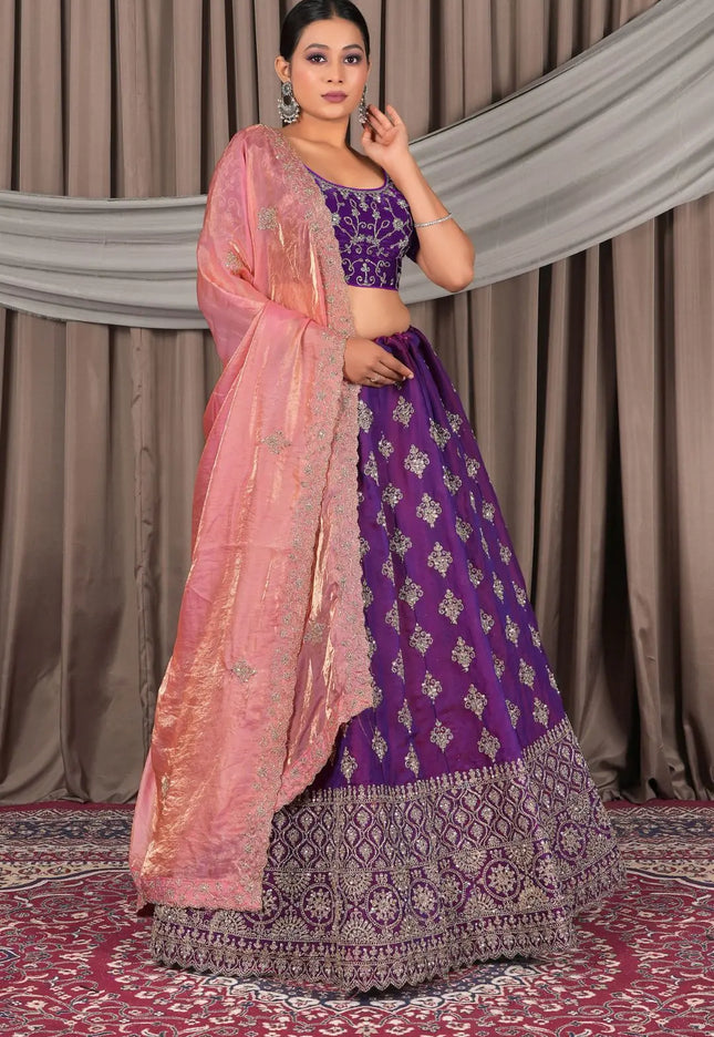Woman wearing a traditional purple and pink lehenga choli with dupatta