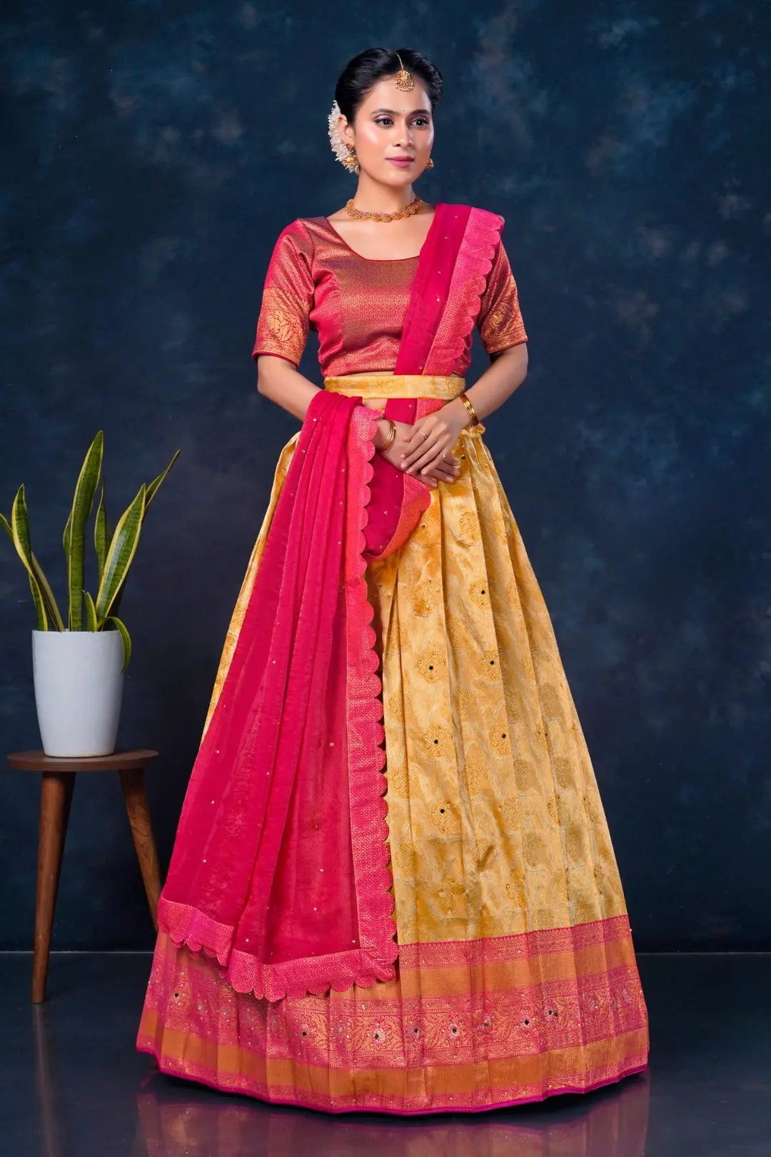 Woman wearing a traditional outfit with a pink and gold lehenga choli with dupatta