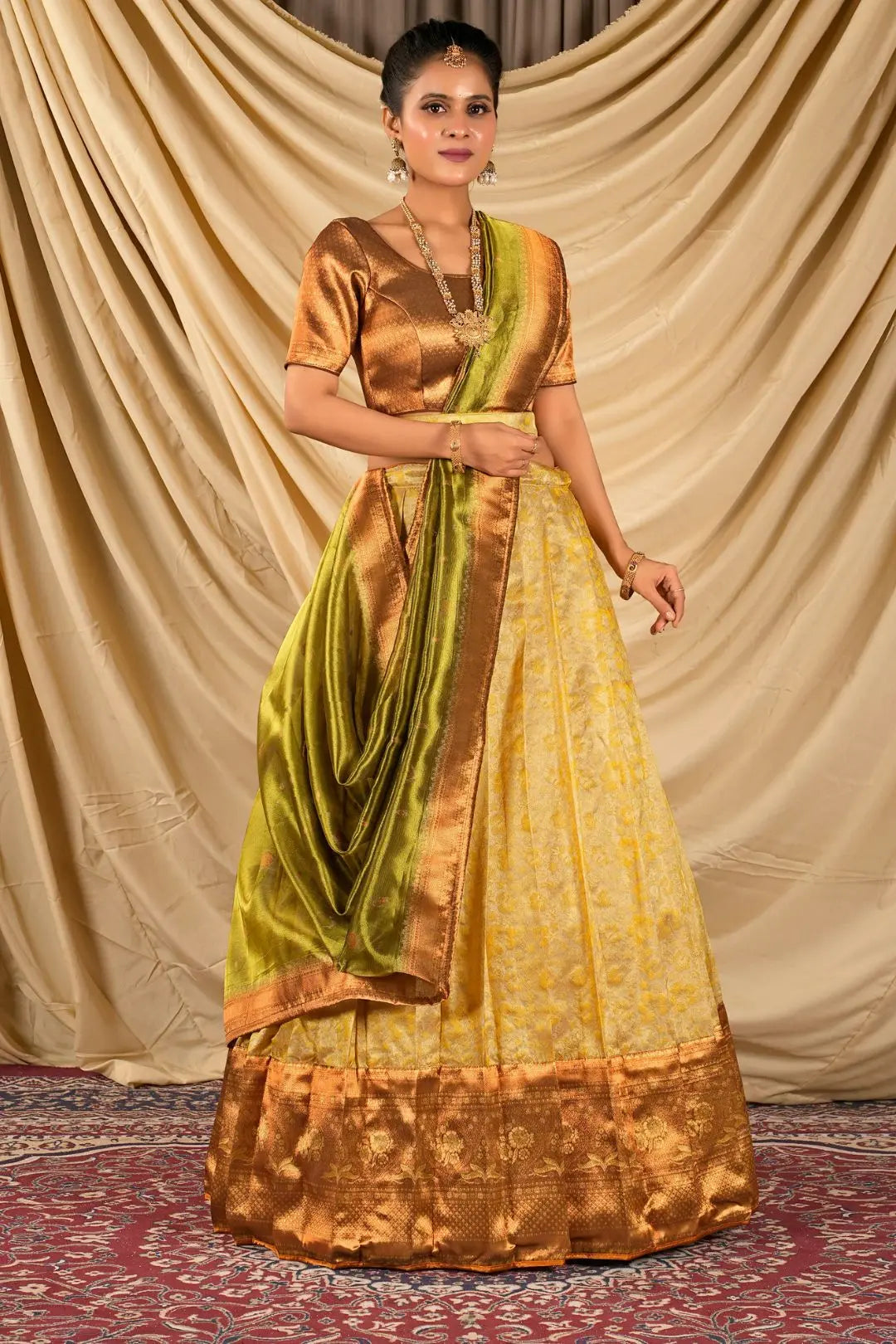 Woman wearing a traditional gold and green lehenga choli with dupatta