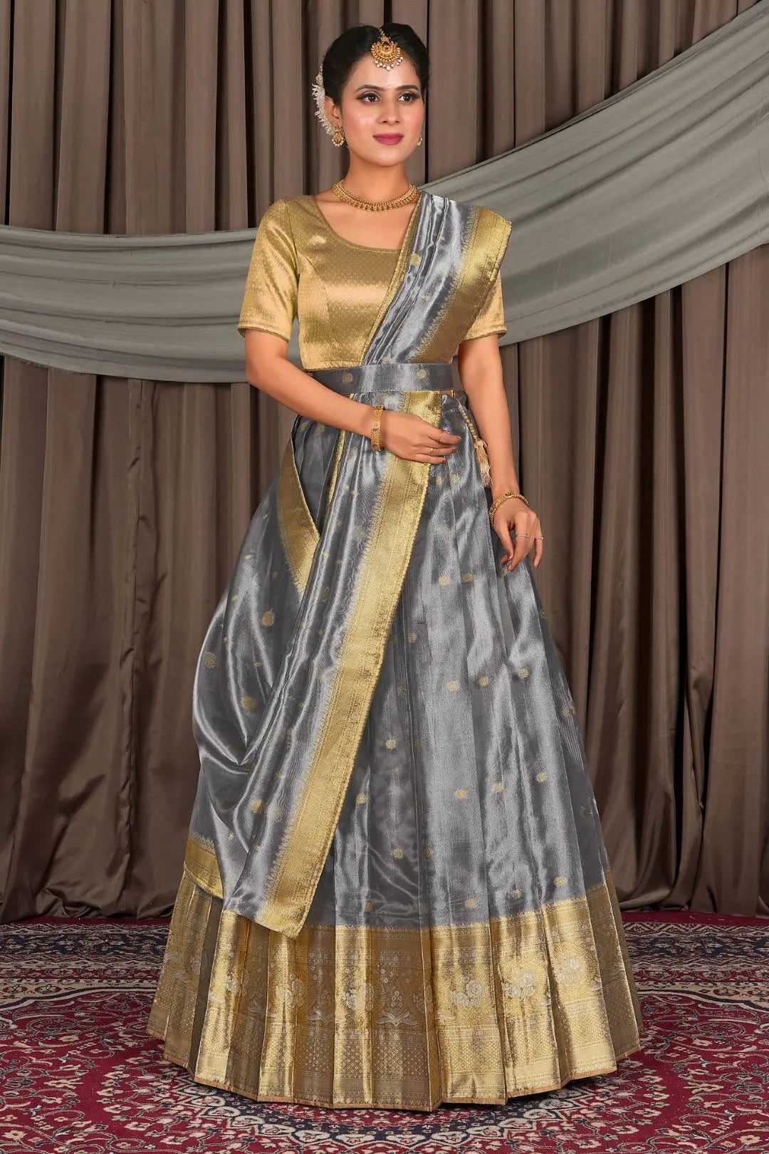 Woman in a traditional gray lehenga and gold blouse with matching dupatta