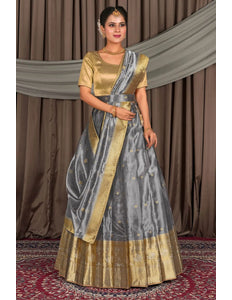 Woman in a traditional gray lehenga and gold blouse with matching dupatta