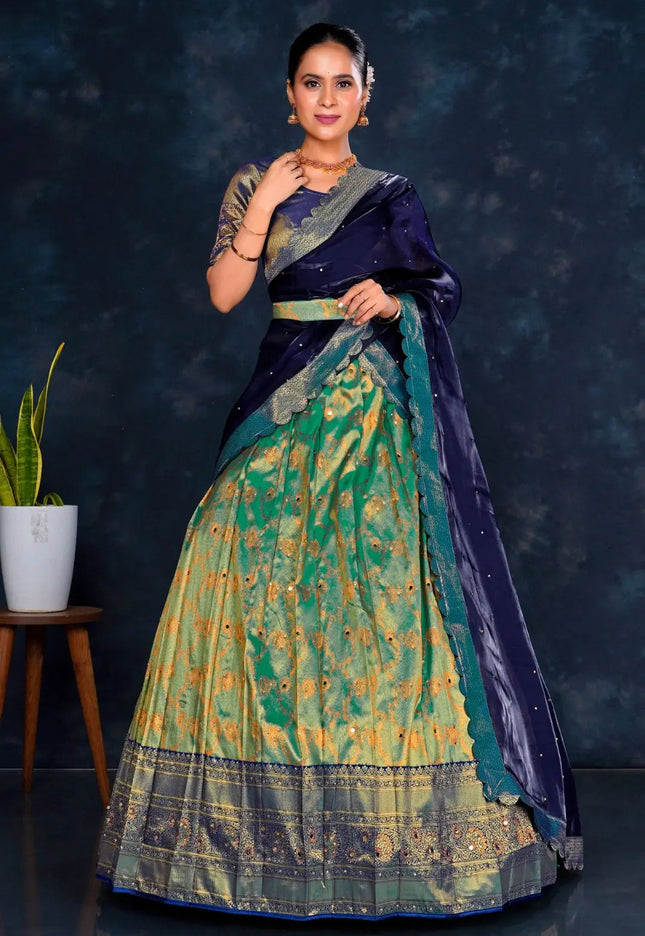 Woman wearing a traditional blue and green lehenga choli with dupatta