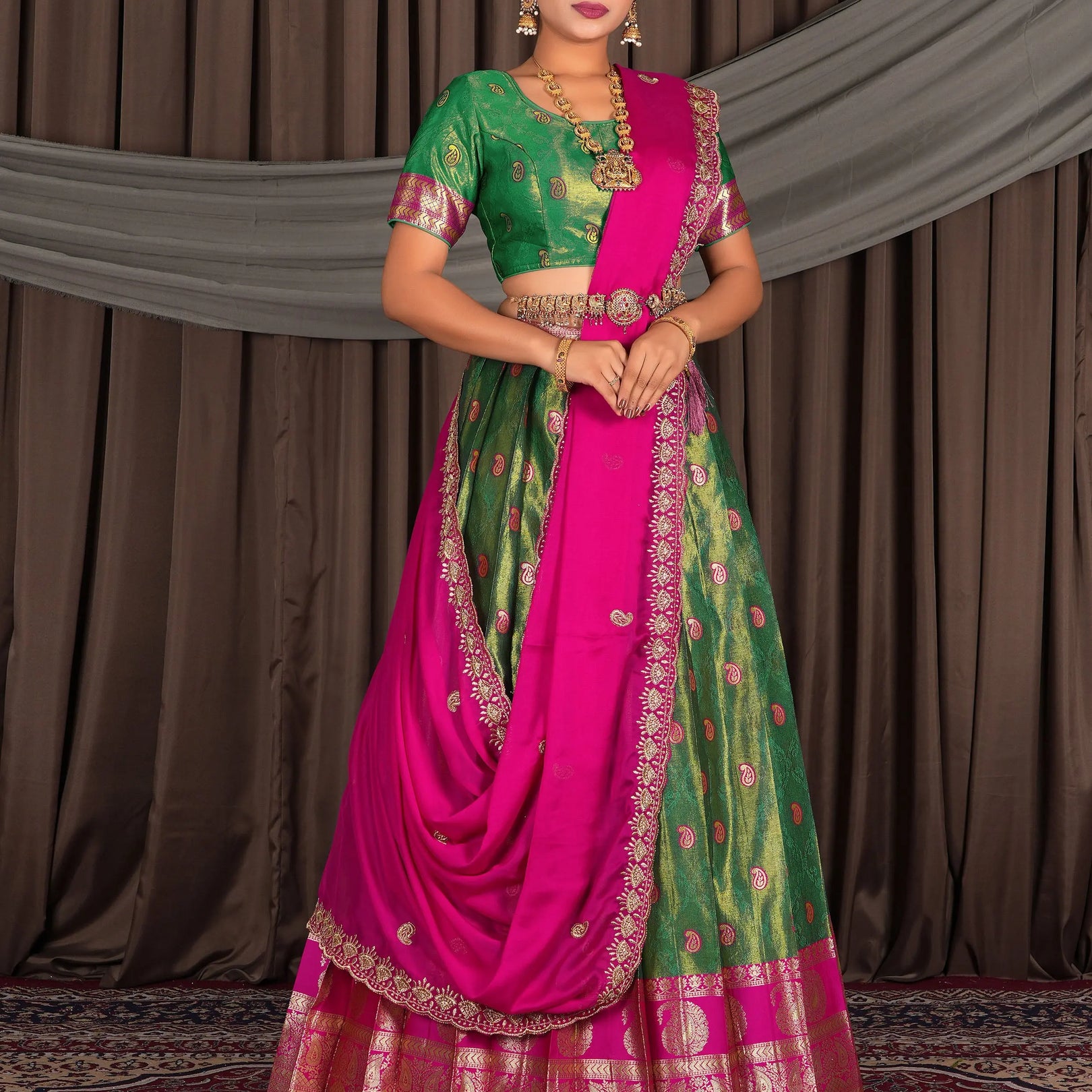 Woman wearing a traditional green and pink lehenga choli with dupatta