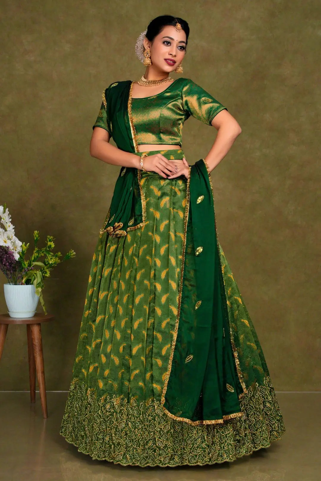 Woman wearing a green traditional outfit with gold patterns