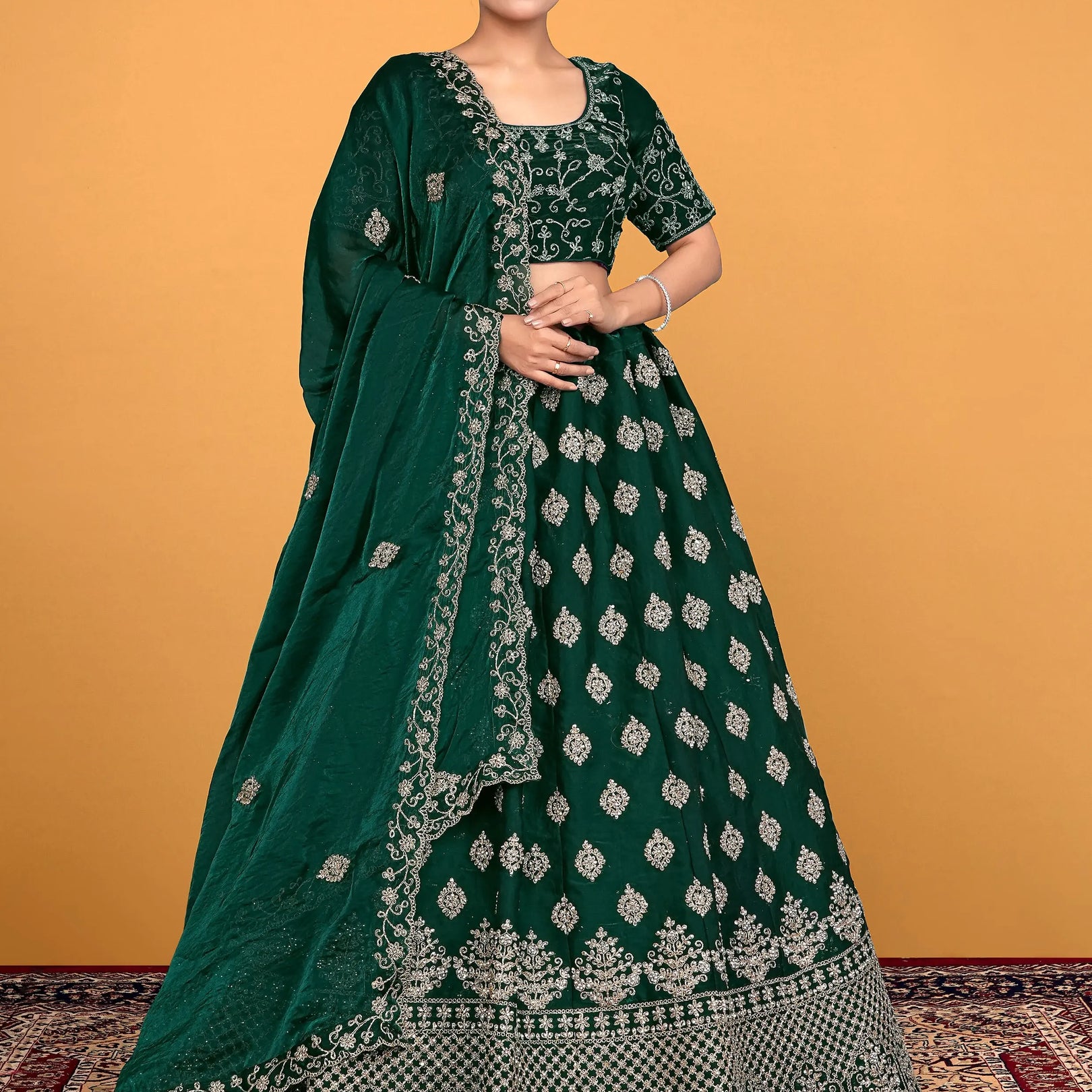 Woman wearing a green embroidered traditional lehenga choli