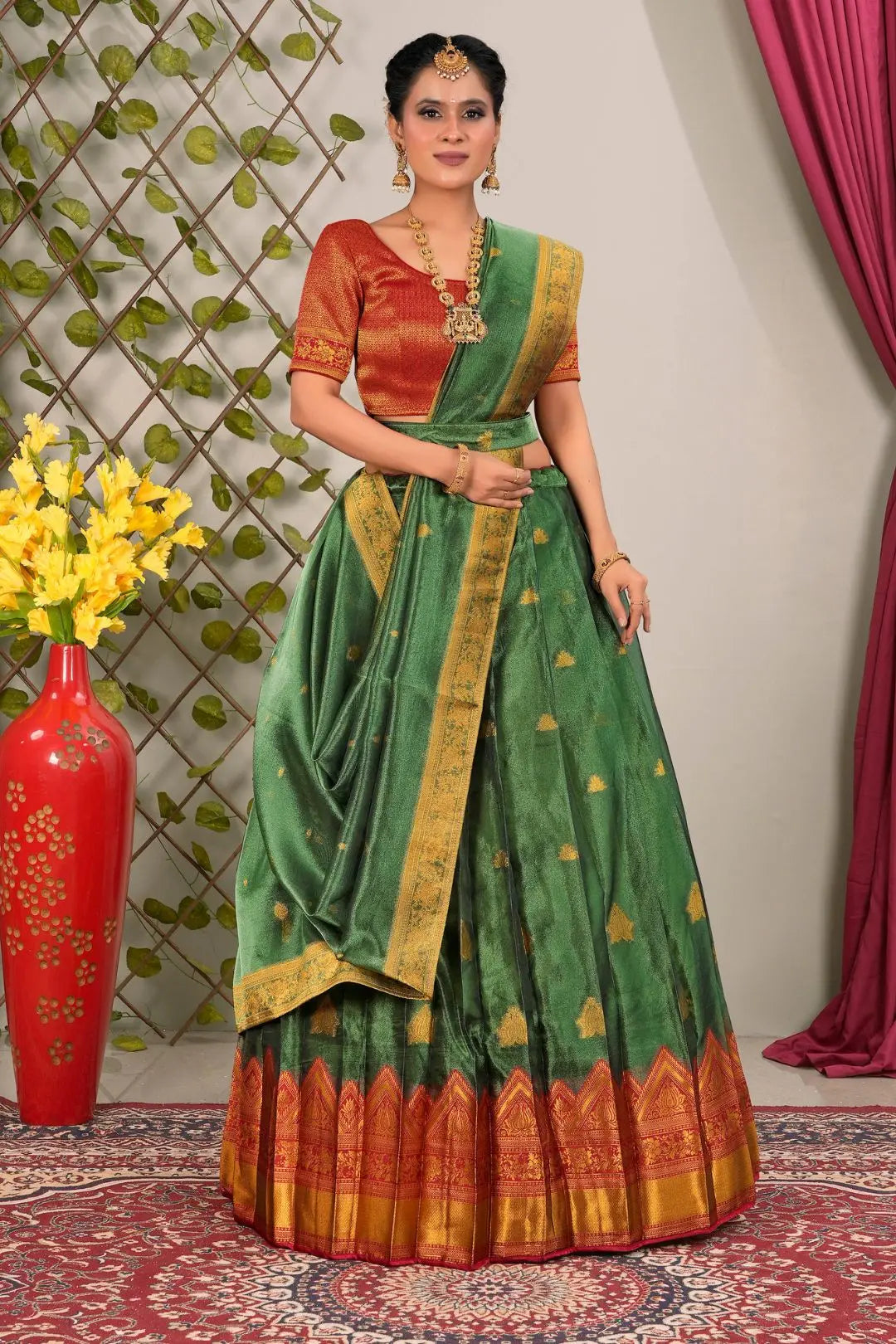 Woman wearing a green and Red lehenga choli with dupatta
