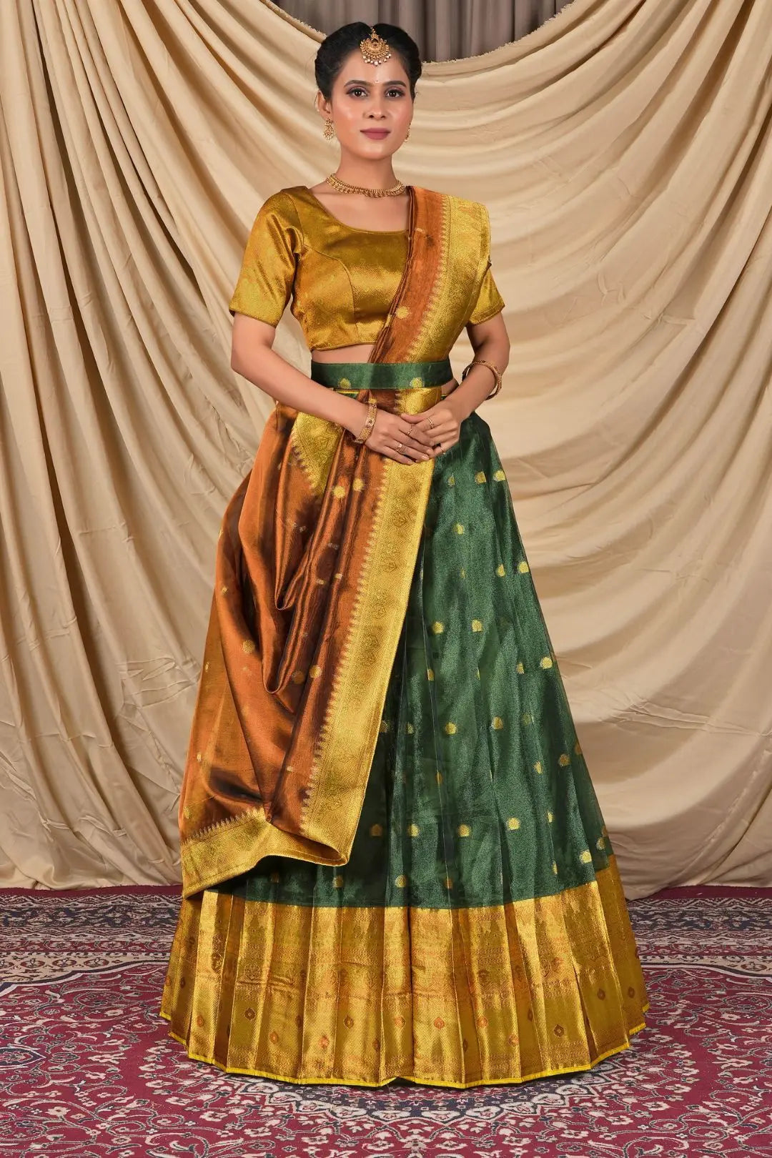 Woman wearing a traditional green and gold lehenga choli with dupatta