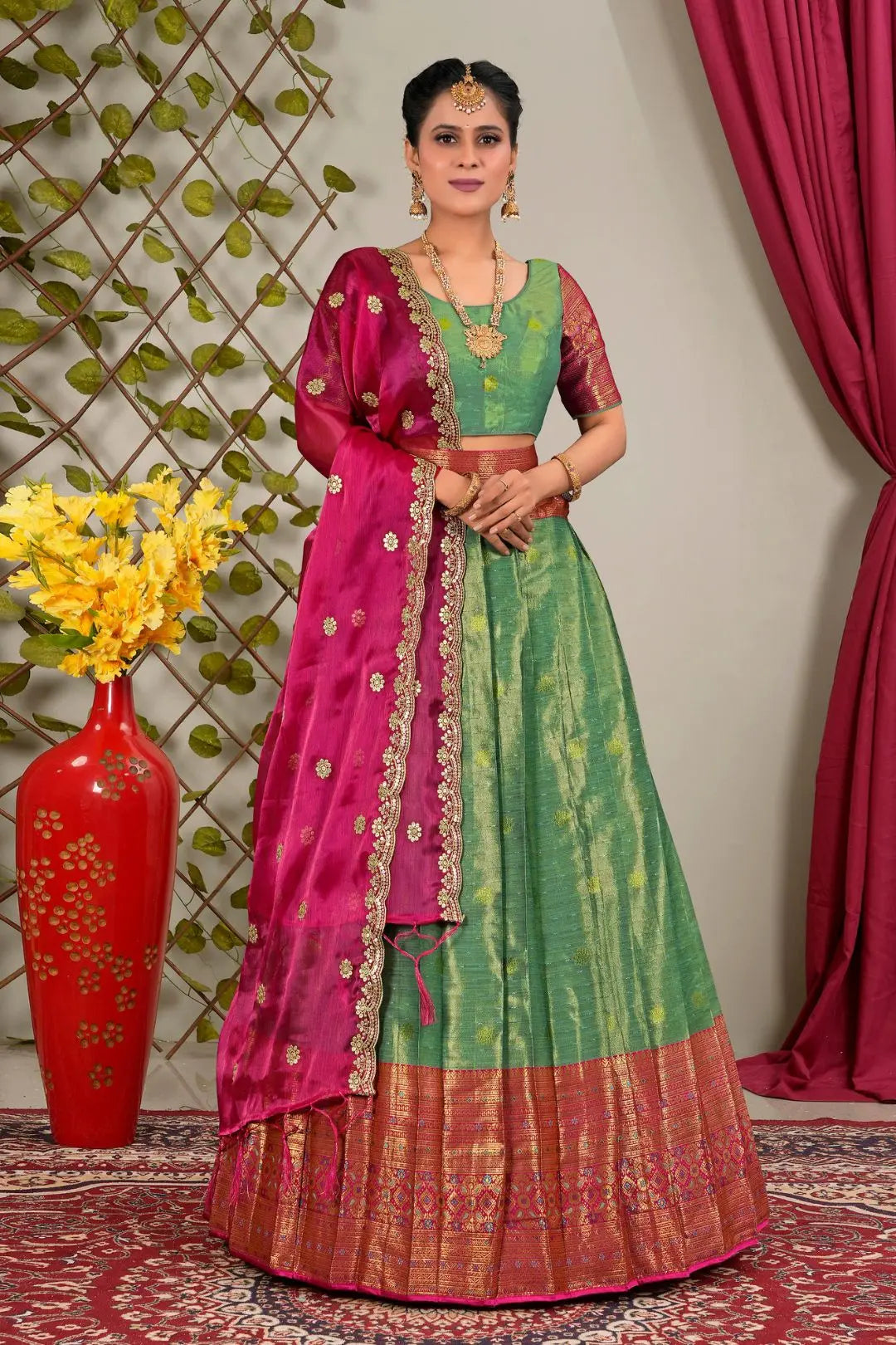 Woman in a green and pink traditional lehenga choli with matching blouse