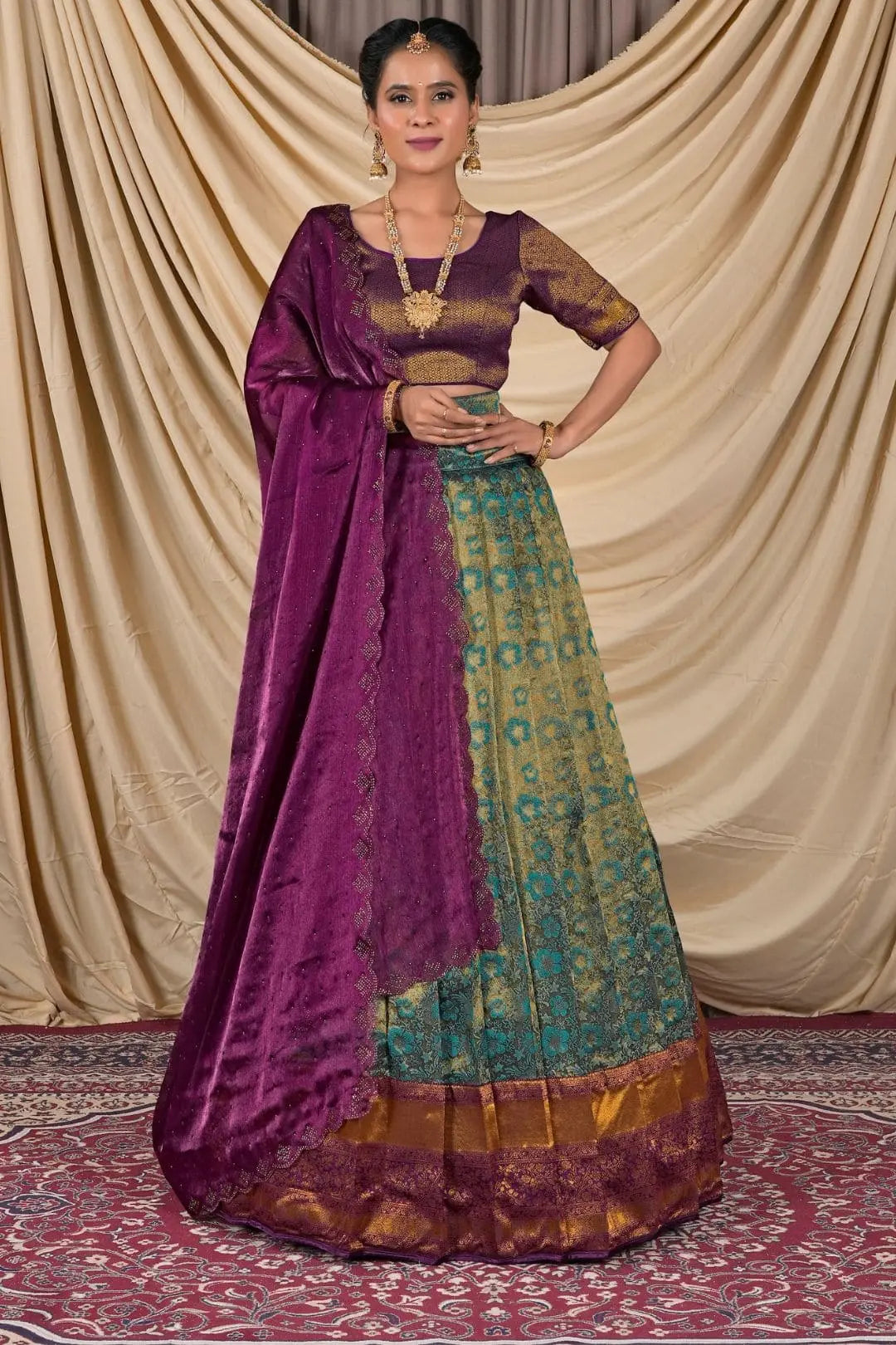Woman wearing a traditional purple and green lehenga choli with dupatta