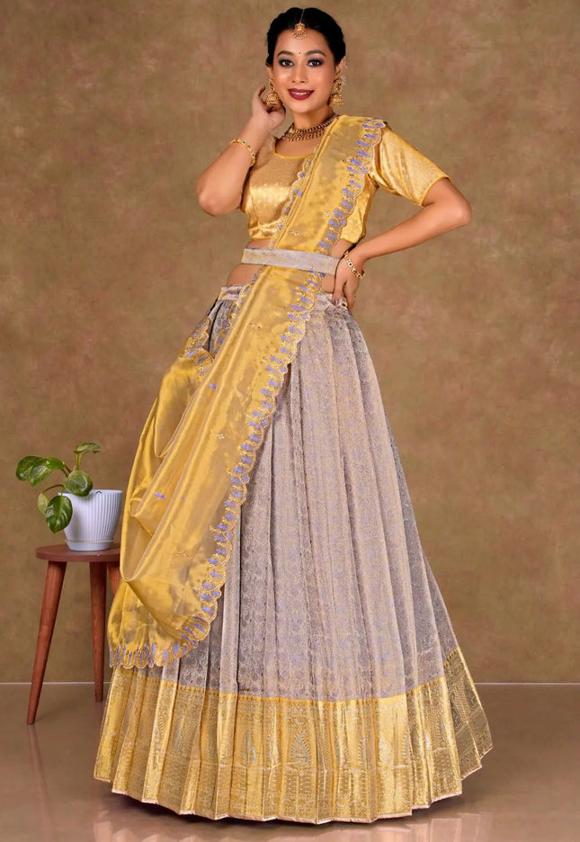 Woman wearing a yellow and lavender lehenga choli with dupatta