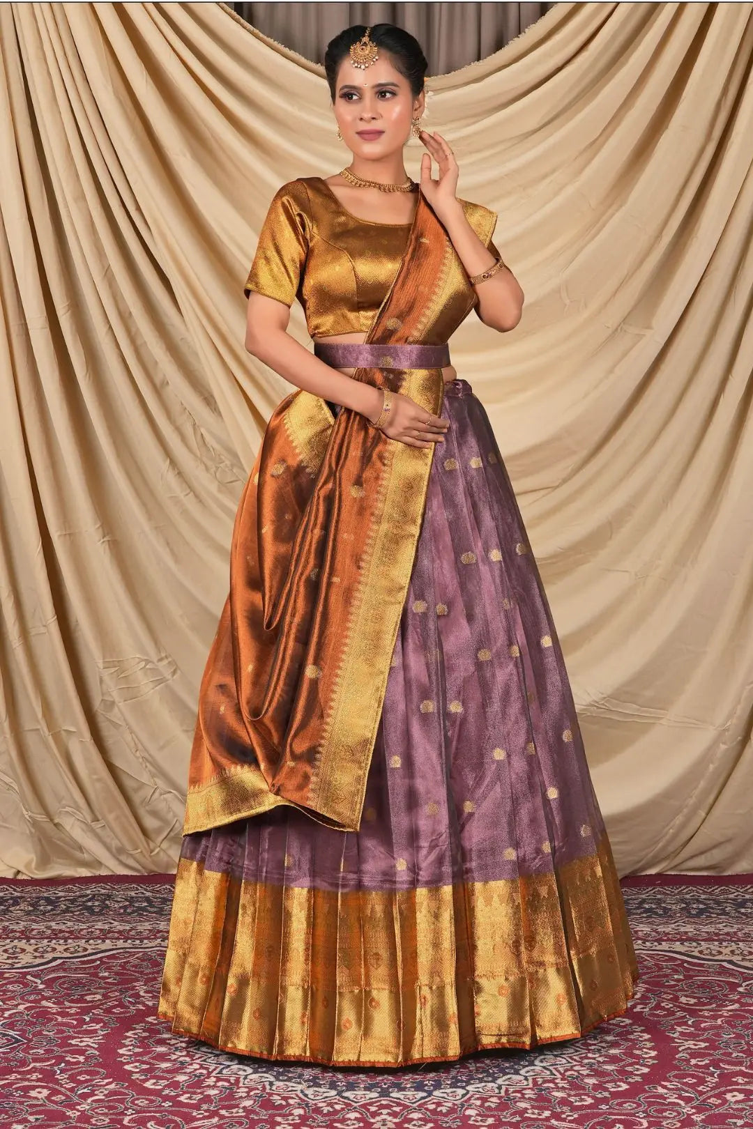 Woman wearing a traditional gold and purple lehenga choli with dupatta