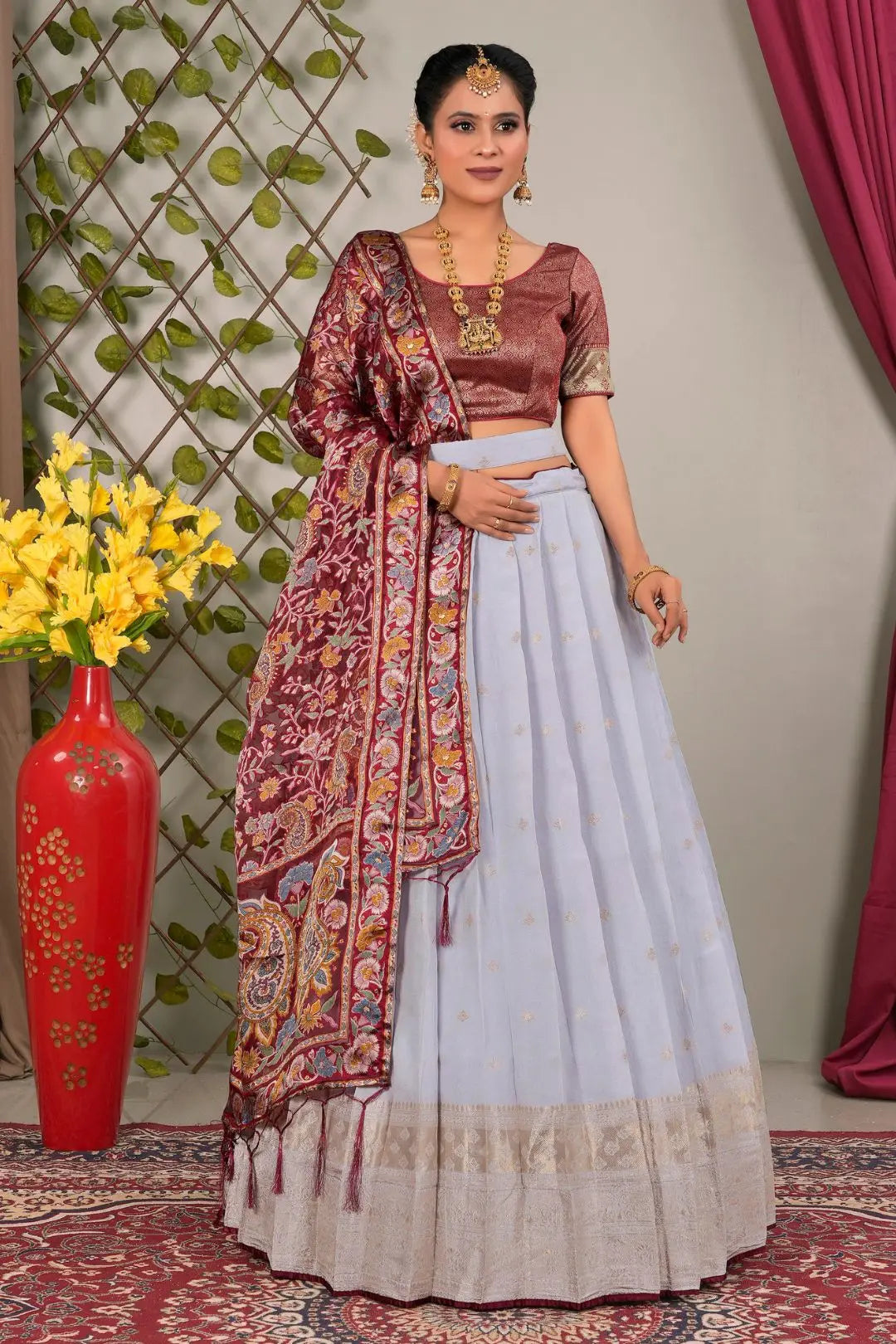 Woman in traditional outfit with a maroon and lavender lehenga choli