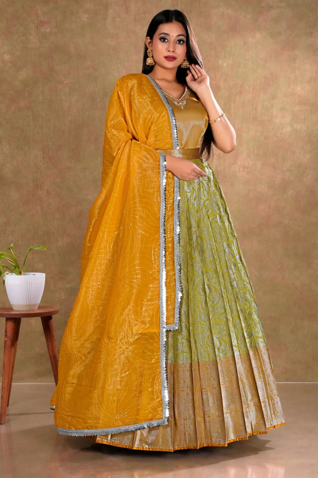 Woman wearing a mustard yellow and lemon long gown with dupatta