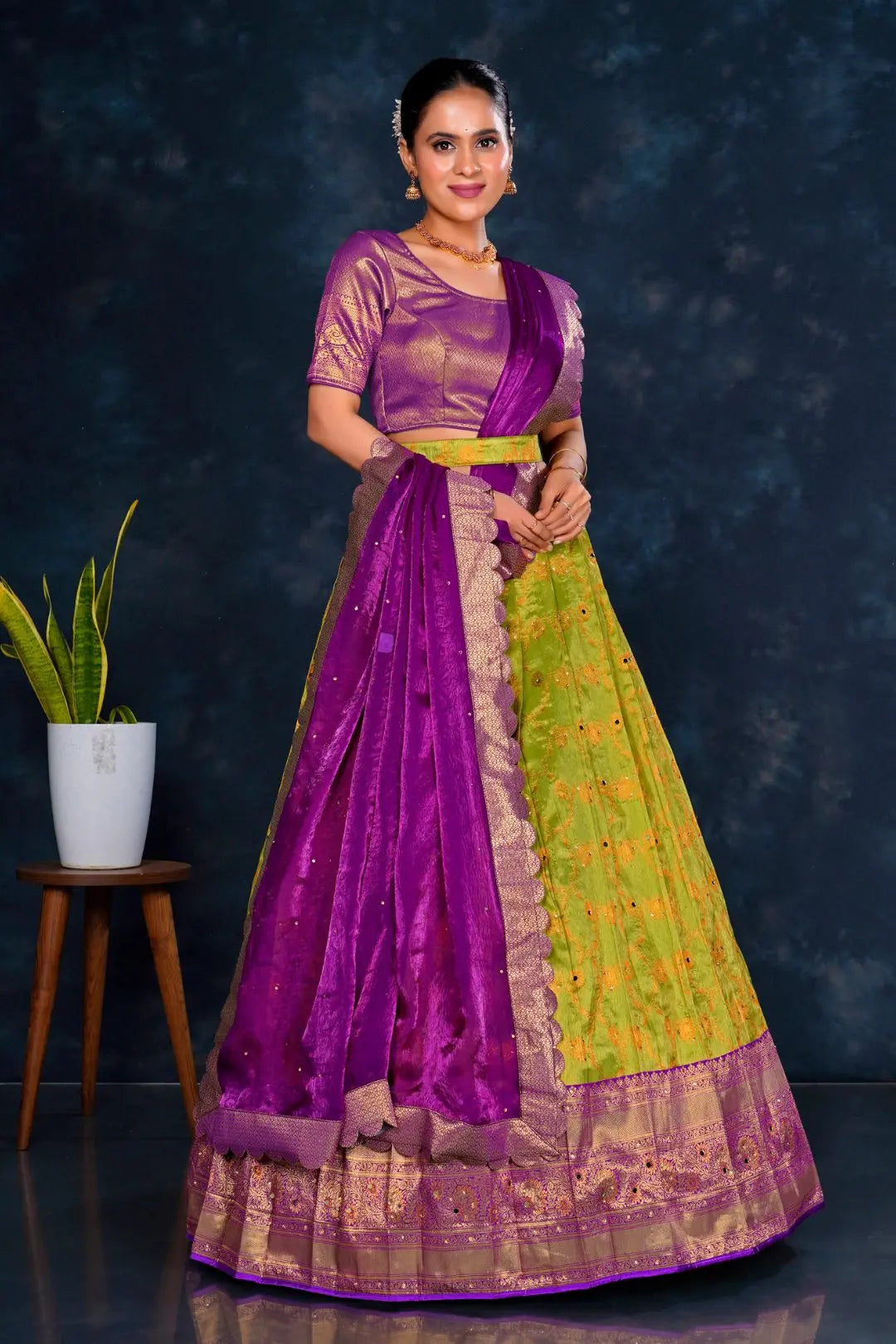 Woman wearing a purple and green lehenga choli with dupatta