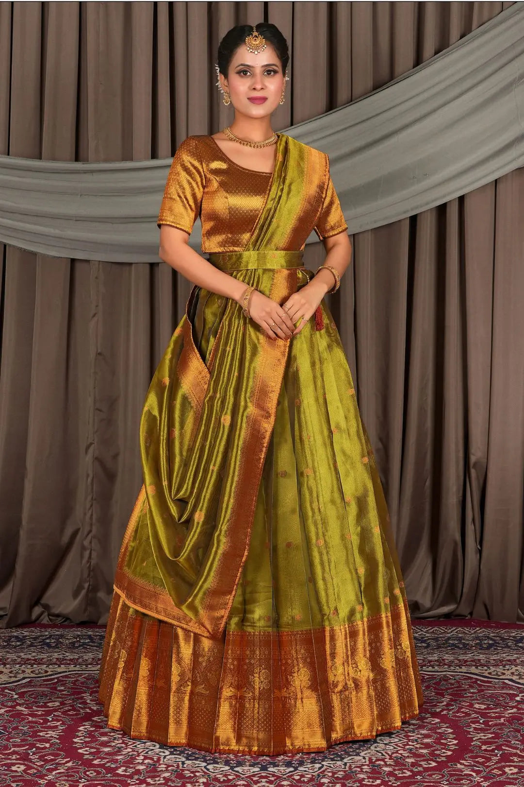 Woman wearing a traditional green and gold lehenga with a matching blouse