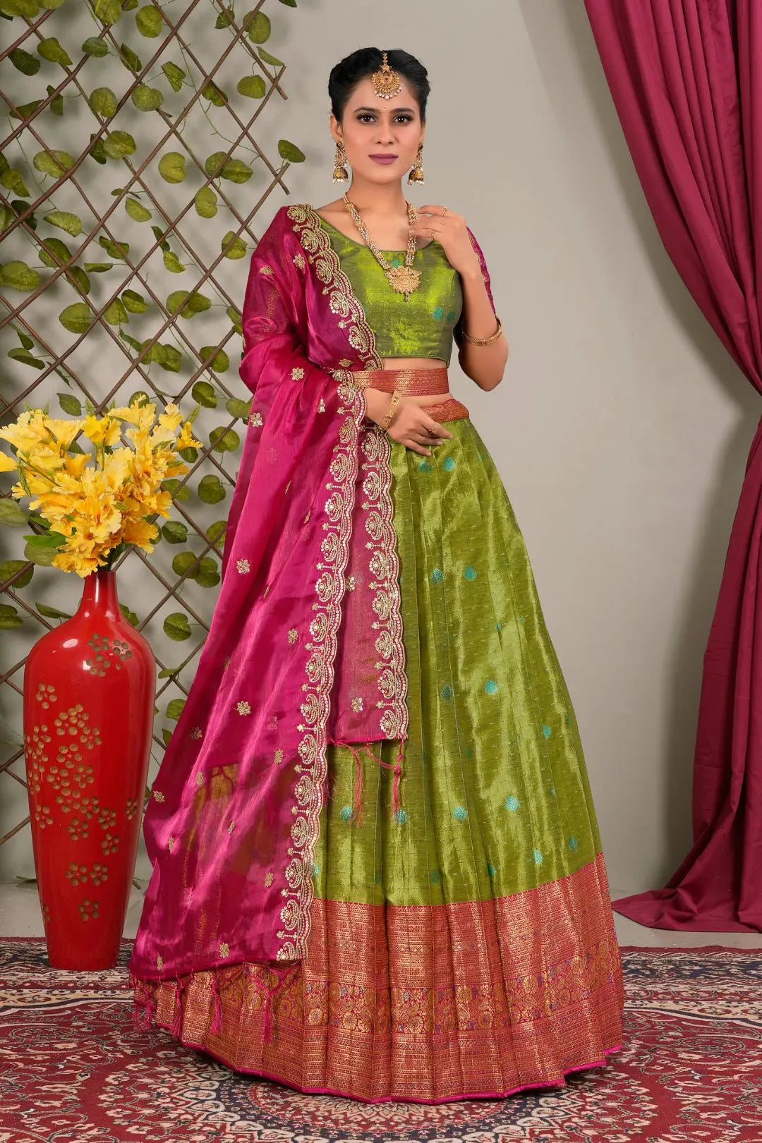 Woman wearing a green and pink traditional lehenga choli with dupatta