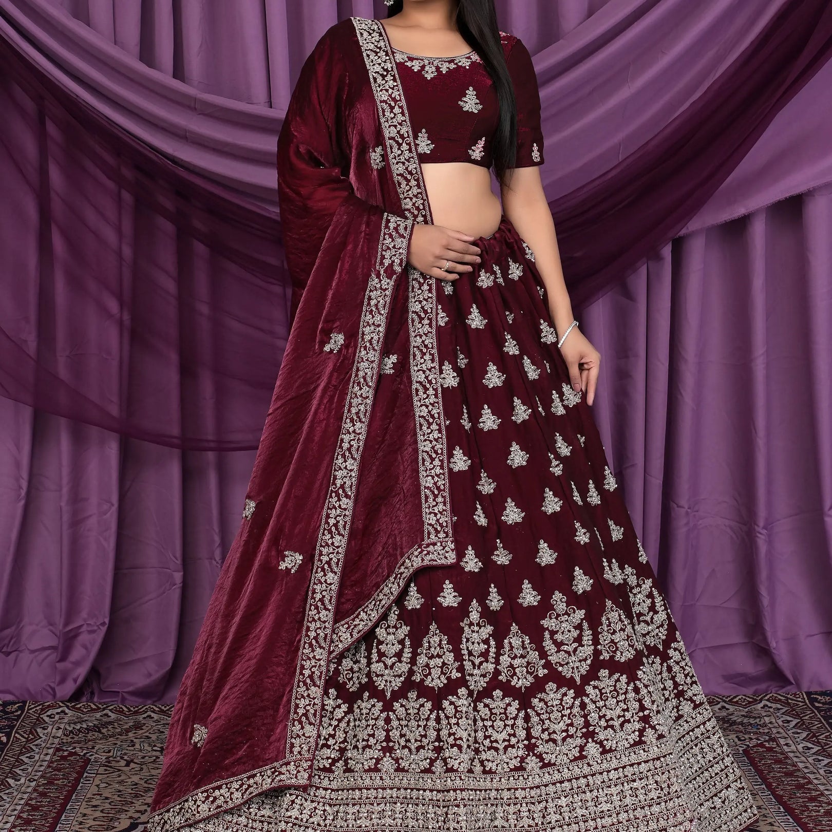 Woman wearing a maroon embroidered traditional lehenga choli
