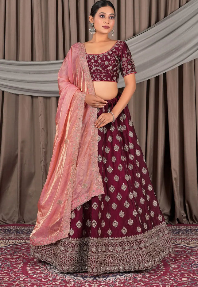 Woman wearing a maroon and pink traditional lehenga choli with dupatta