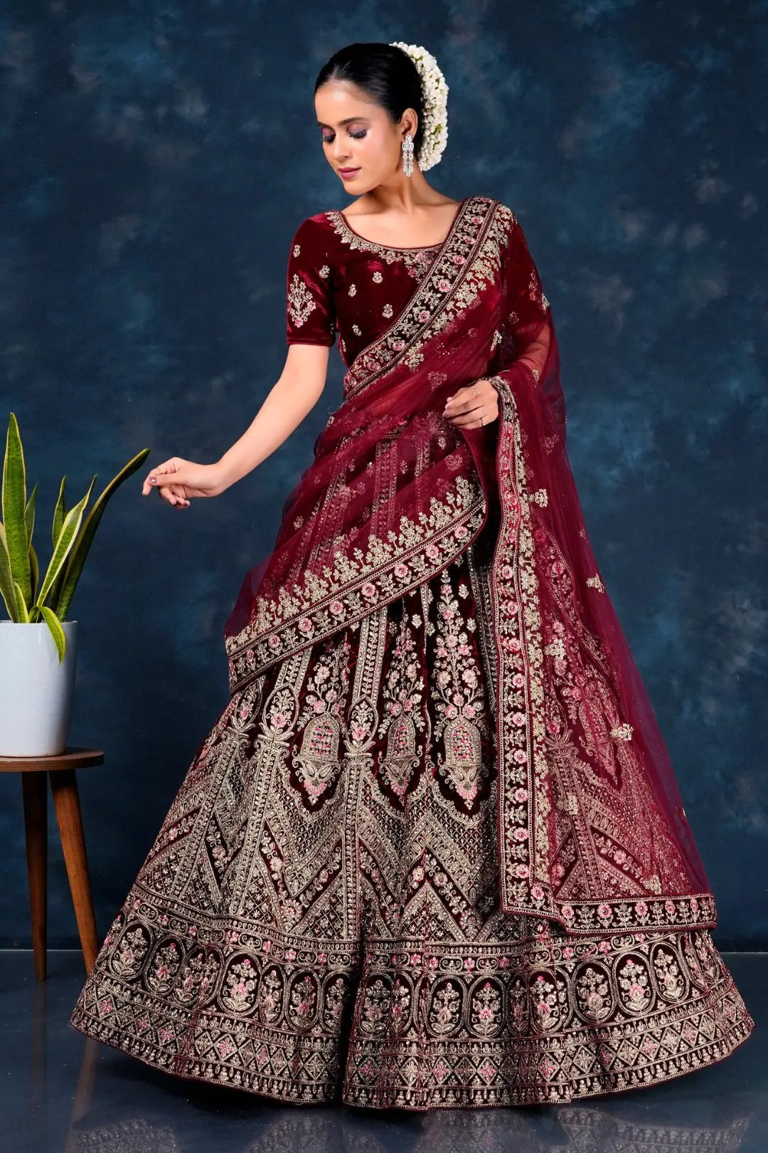Woman in a maroon embroidered traditional lehenga choli with dupatta