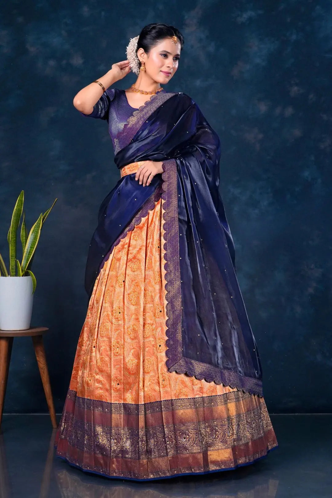 Woman wearing a traditional lehenga with a dark blue and orange pattern