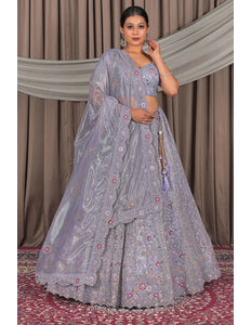 Woman in a traditional lavender embroidered lehenga with a matching dupatta