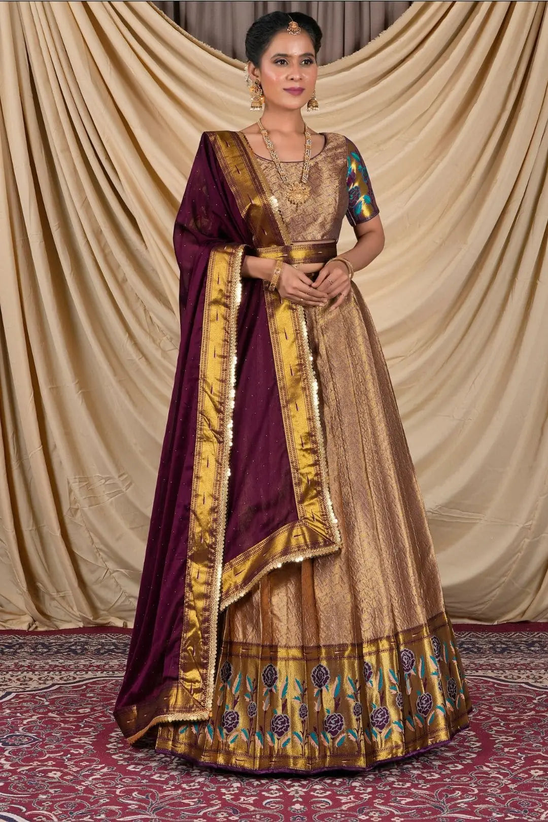Woman wearing a traditional gold and purple lehenga choli with dupatta