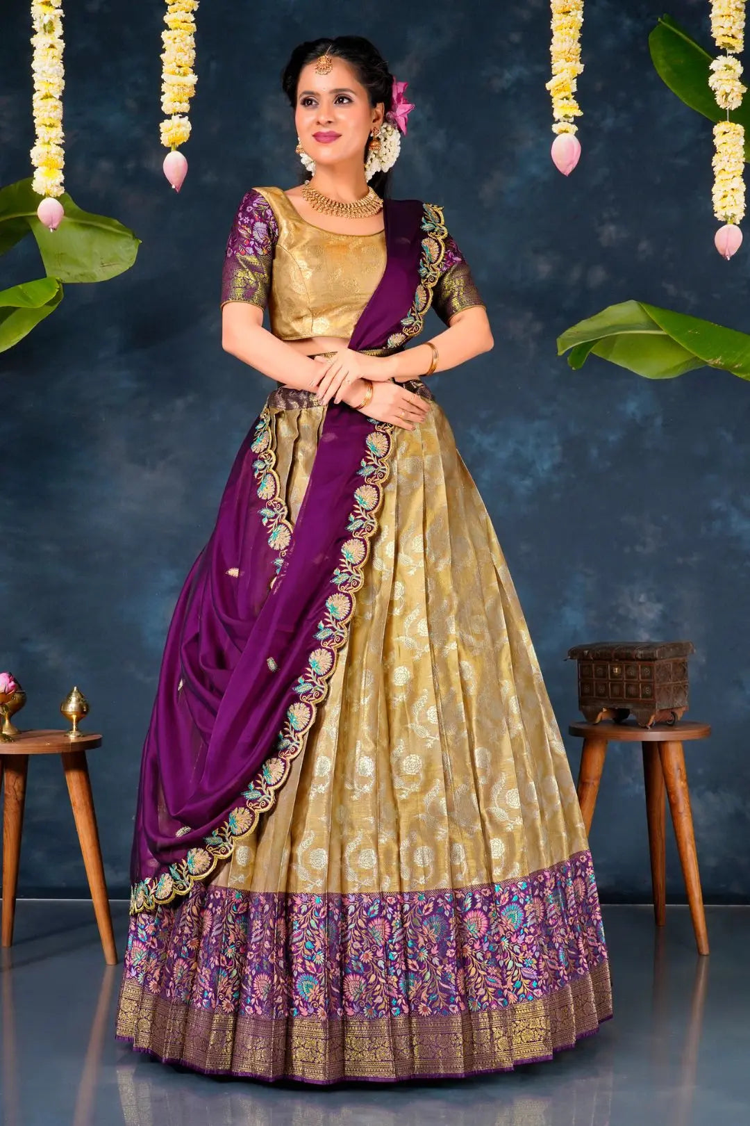 Woman in a traditional gold and purple lehenga choli with dupatta
