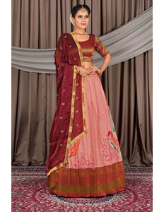 Woman wearing a traditional maroon and pink saree with a gold border