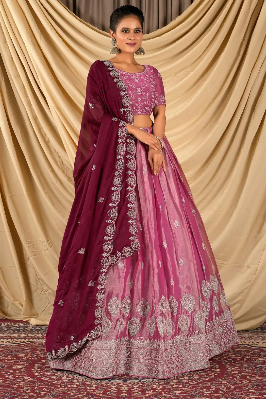 Woman wearing a pink and purple traditional lehenga choli with dupatta