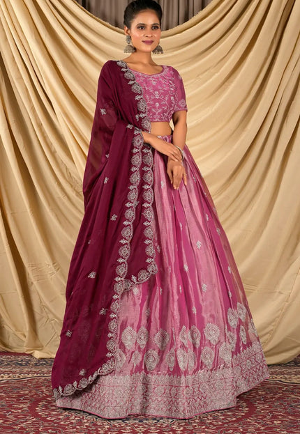 Woman wearing a pink and purple traditional lehenga choli with dupatta