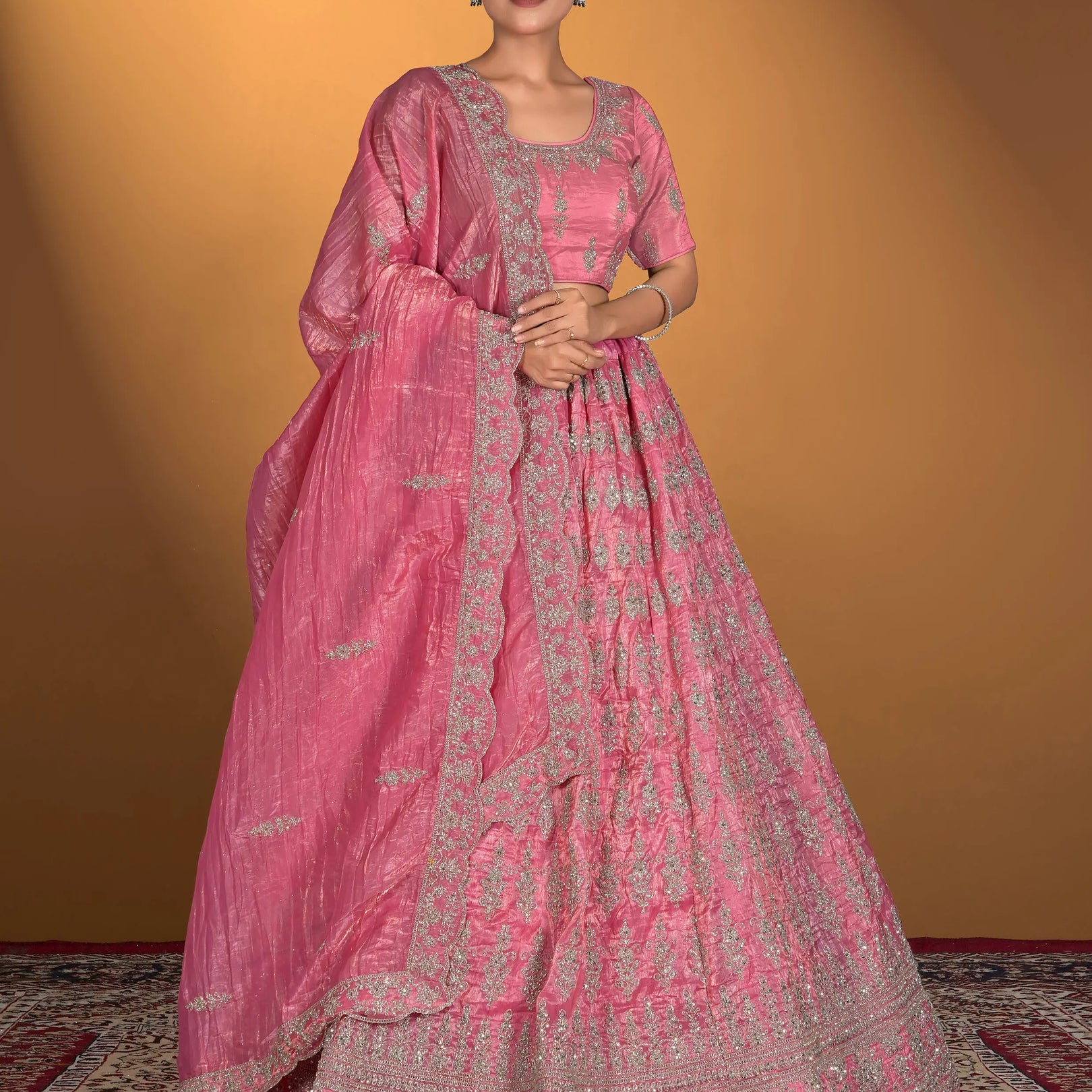 Woman wearing a pink traditional outfit with intricate patterns
