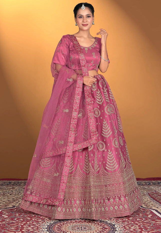 Woman wearing a pink traditional outfit with intricate patterns