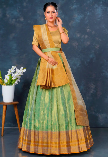 Woman wearing a traditional green and yellow lehenga choli with dupatta
