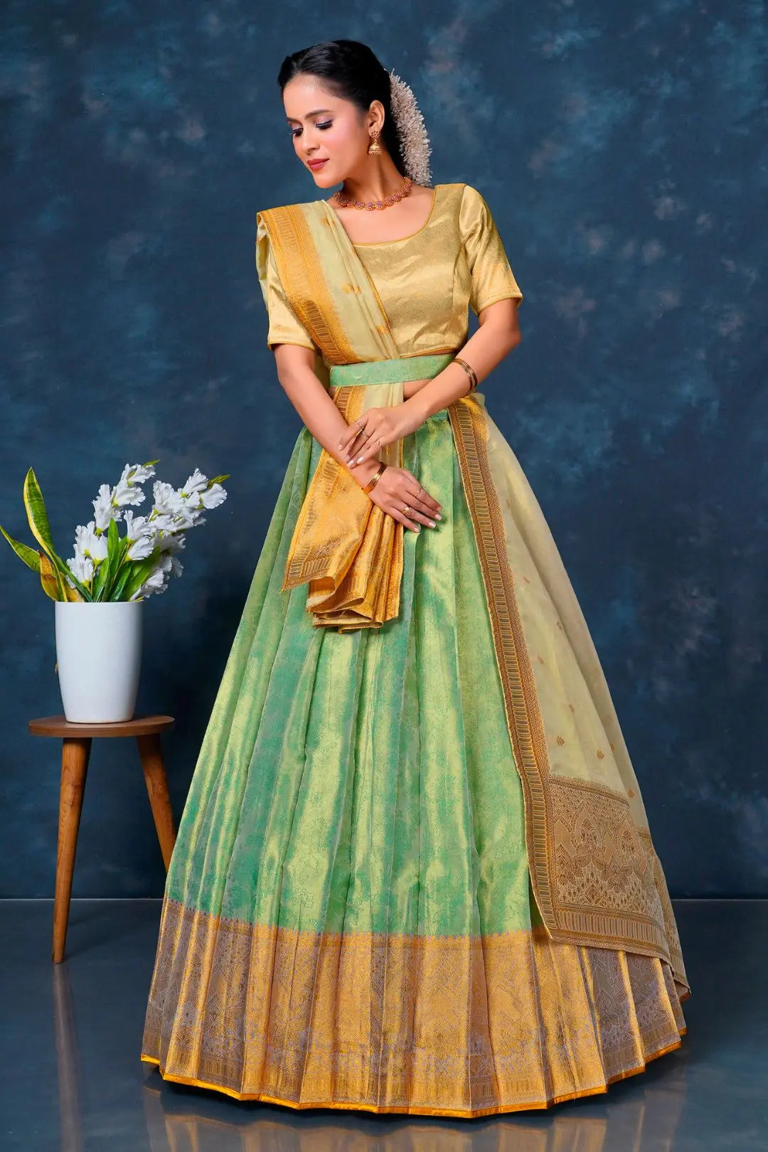 Woman in a green and yellow traditional lehenga choli with dupatta