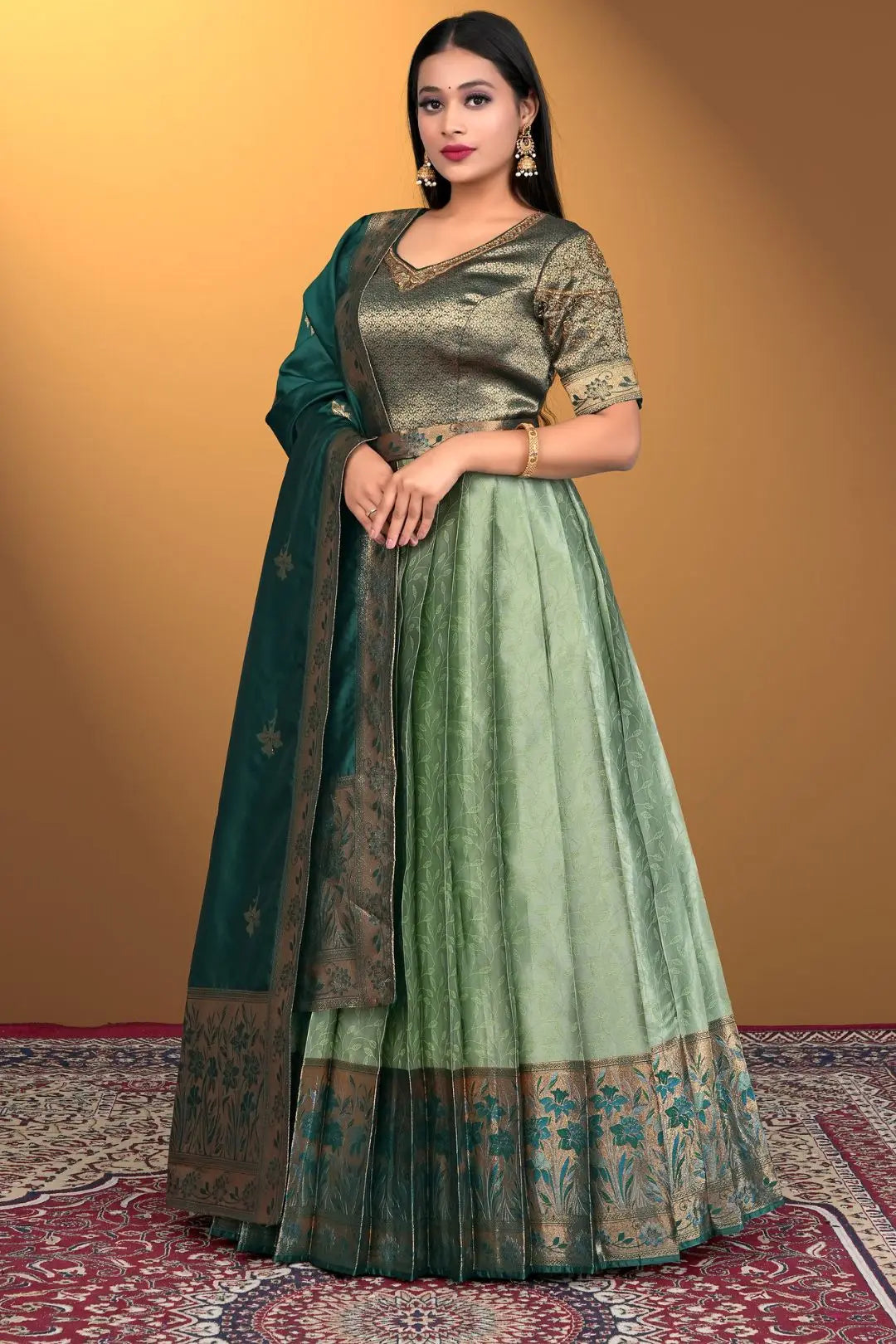 Woman wearing a green traditional outfit with a matching dupatta