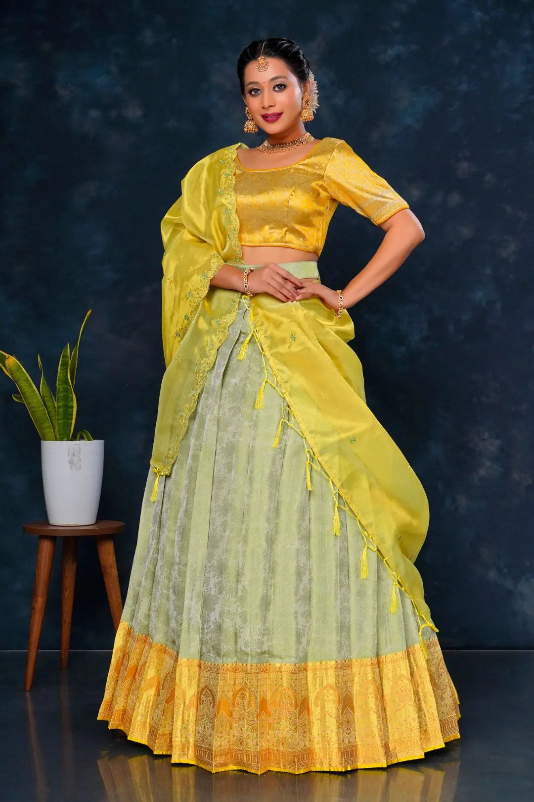 Woman in a yellow and green traditional lehenga choli with dupatta