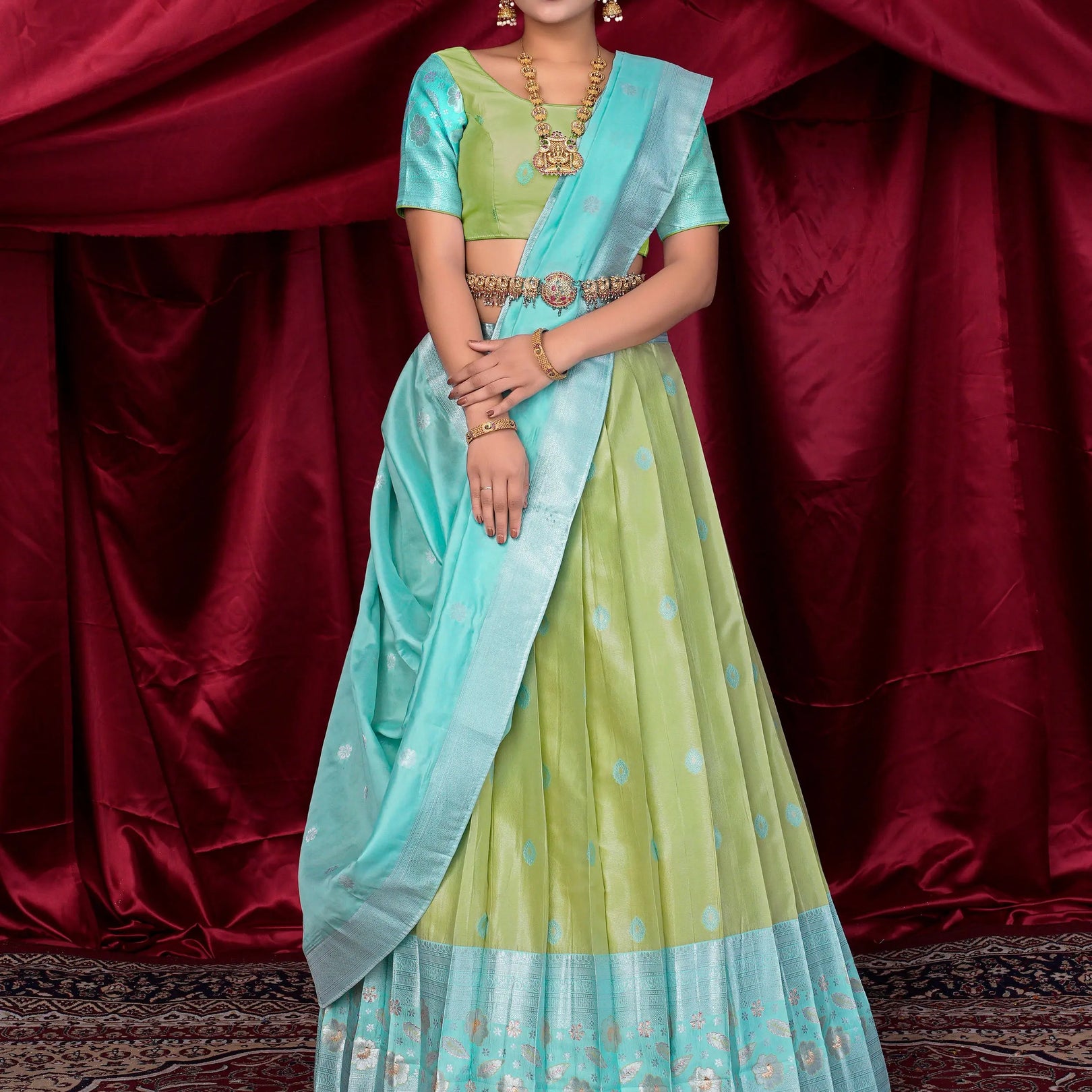 Woman in a traditional outfit with a light blue and green lehenga choli
