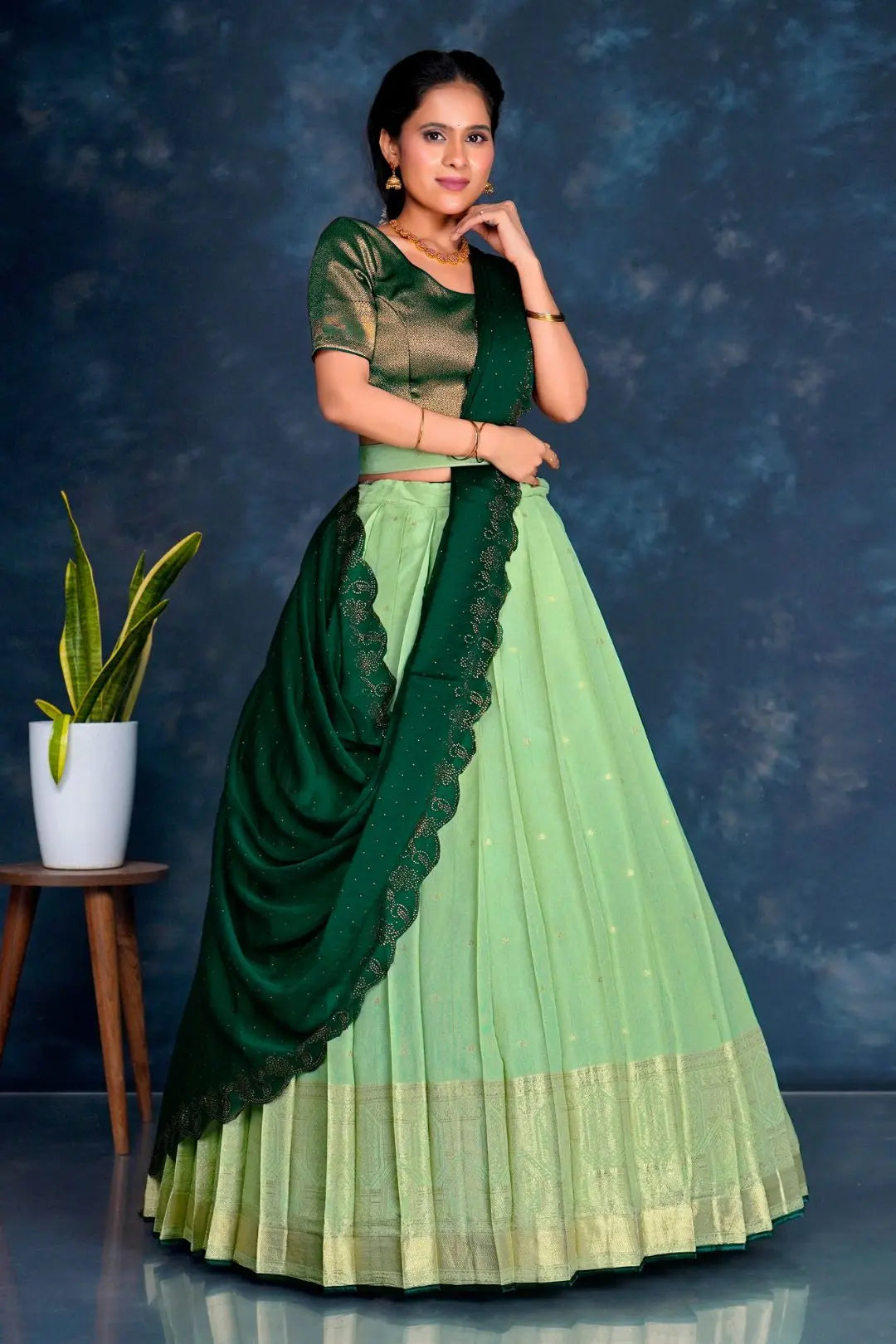 Woman wearing a green and light green traditional lehenga choli with dupatta