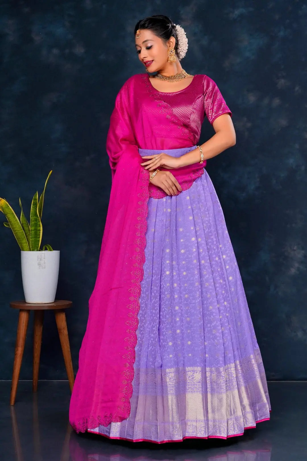 Woman wearing a pink and purple traditional lehenga choli with dupatta