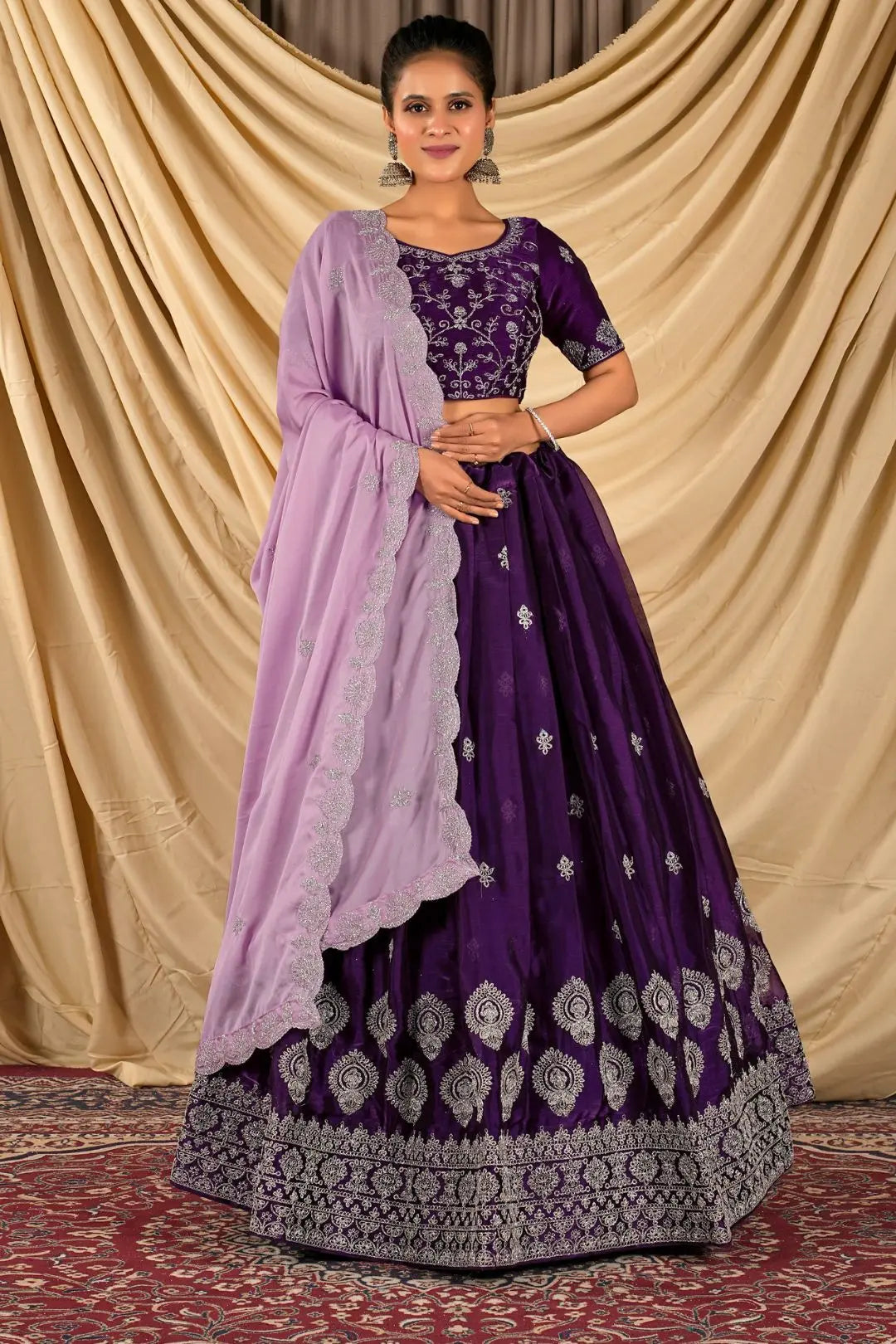 Woman wearing a purple traditional outfit with a matching dupatta