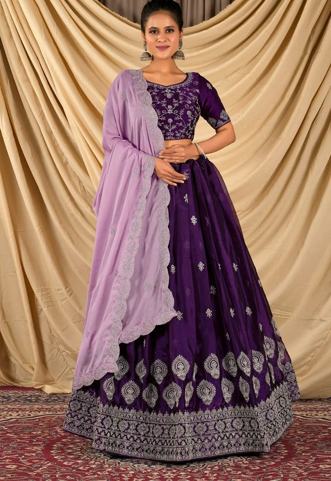 Woman wearing a purple traditional outfit with a matching dupatta