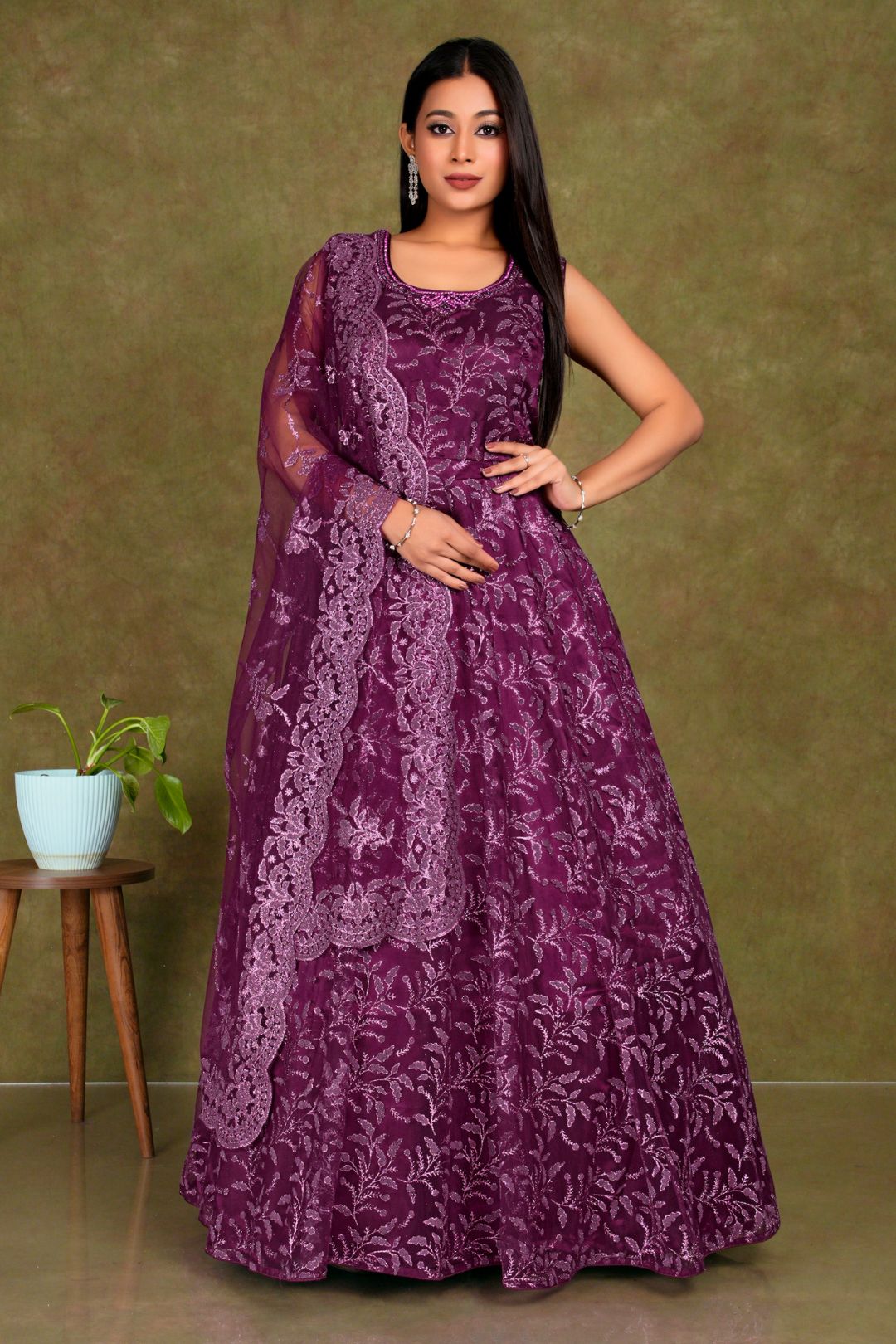 Woman wearing a purple-coloured party wear net gown for women