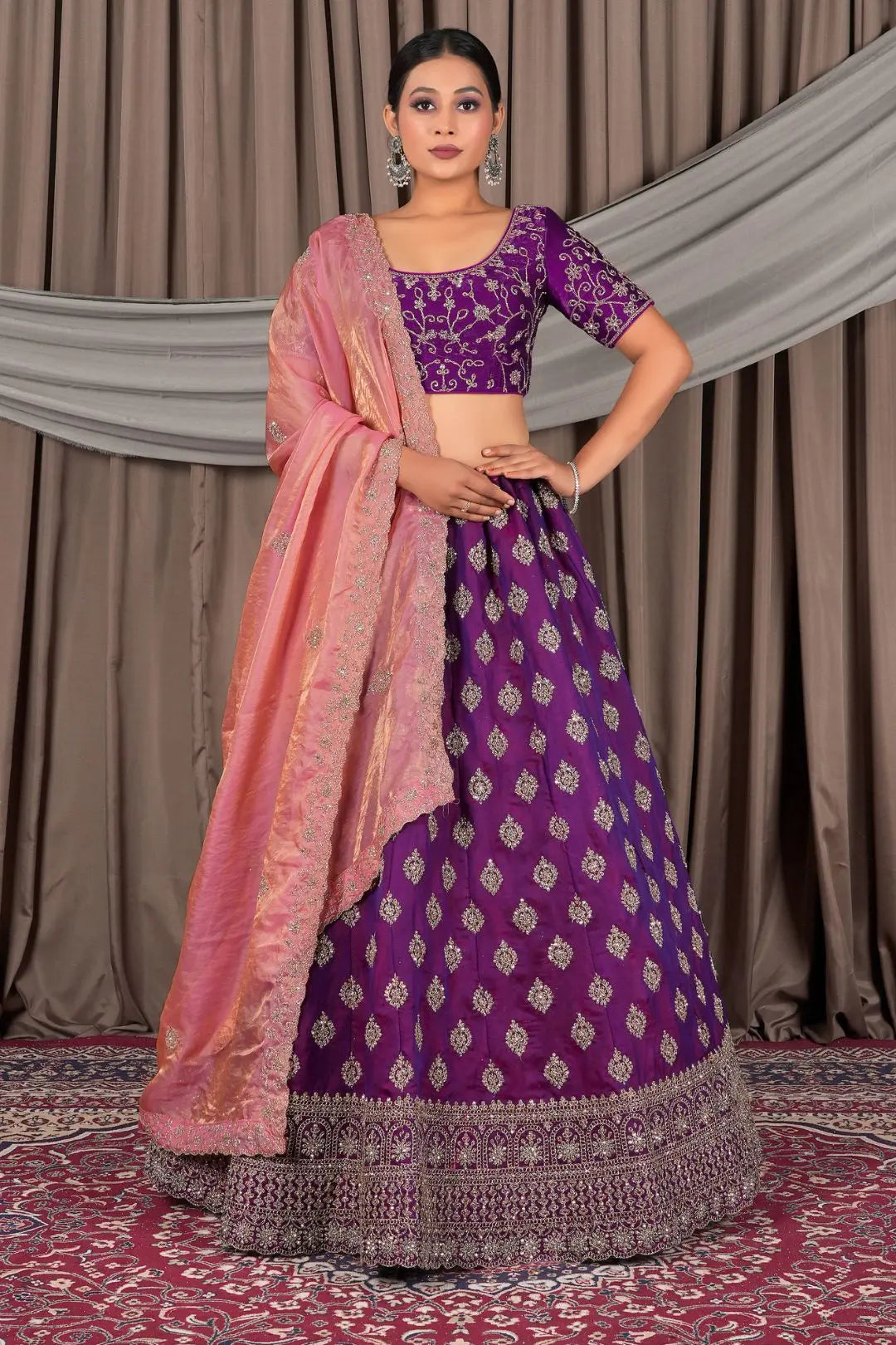 Woman wearing a purple traditional outfit with a pink dupatta
