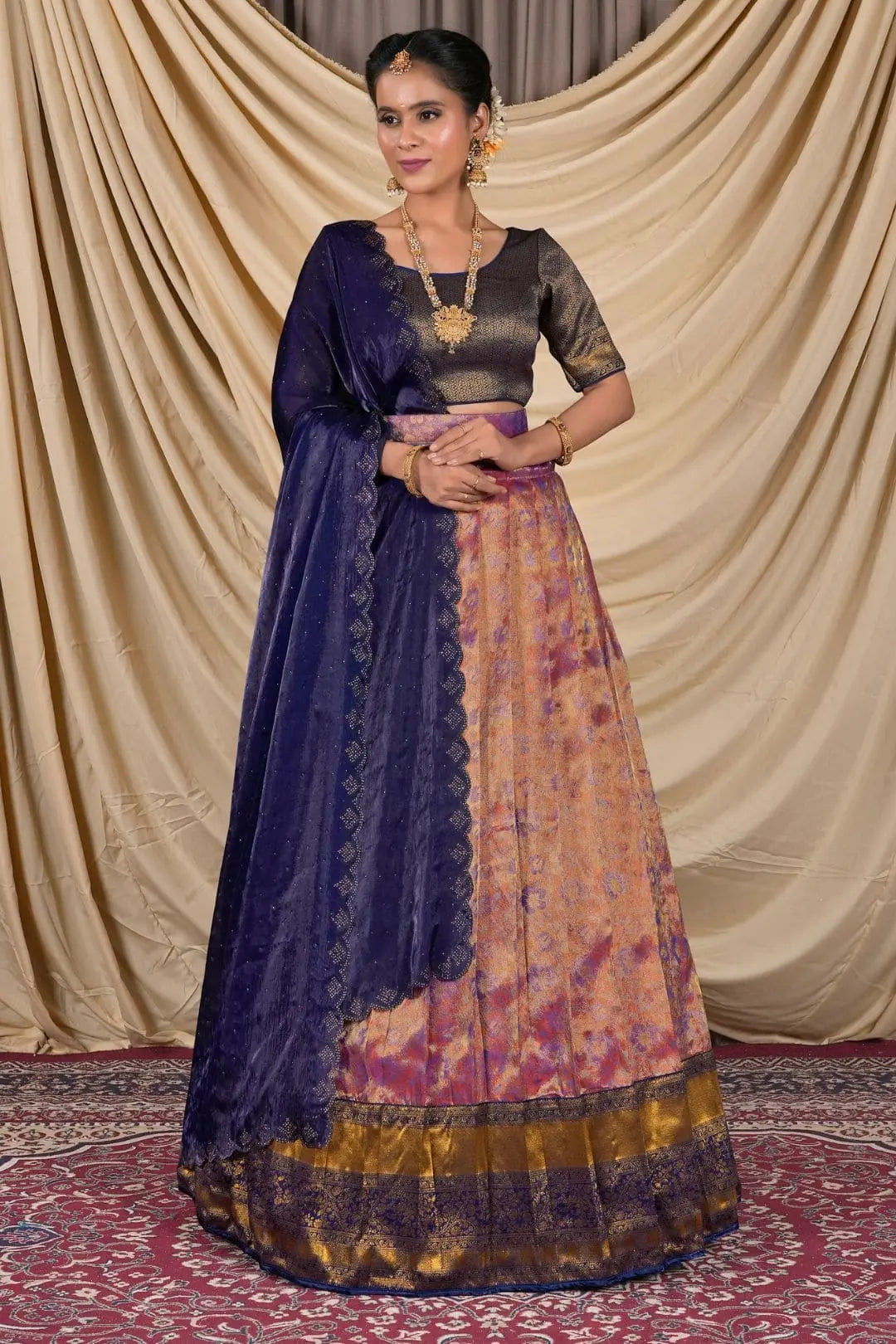 Woman wearing a traditional outfit with a blue dupatta and patterned skirt