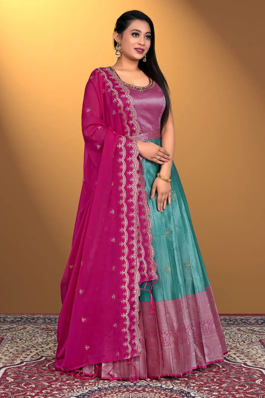 Woman wearing a pink and teal gown with a matching dupatta
