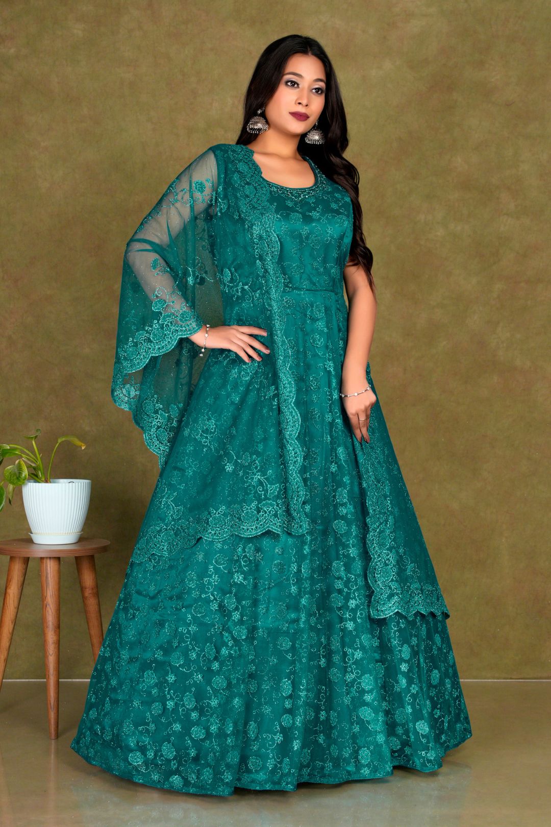Woman wearing a teal embroidered dress Net Gown For Women